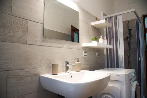 La salle de bains est pourvue d'un lavabo blanc et d'un miroir. dans l'établissement Acqua Holiday House, à Tarente