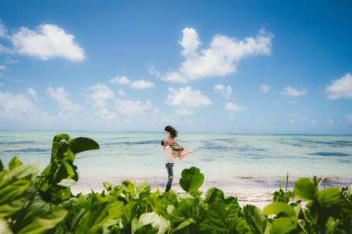 una mujer parada en la playa cerca del océano en M&A Riverside Beach Bungalows, en Chol