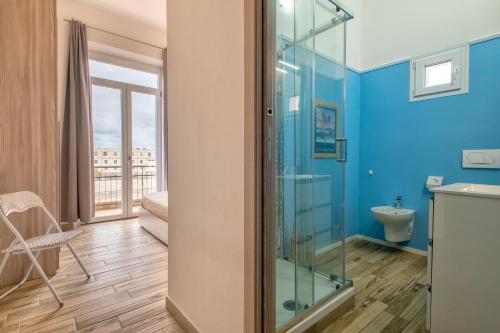 bagno con doccia in vetro e servizi igienici di Casa vacanze la fenice ad Alghero