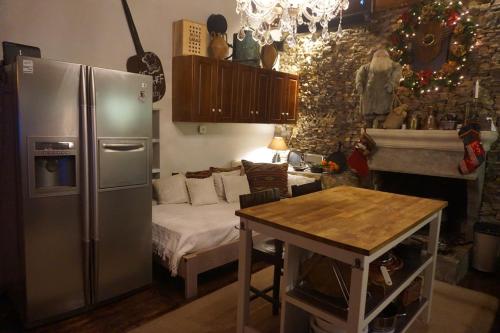 a kitchen with a refrigerator and a table and a bed at ZenTerra Country house with prive swimming pool and view in Matésion