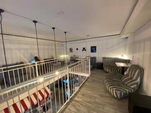 um quarto com duas cadeiras e uma varanda com pessoas em New Generation Hostel Milan Center em Milão