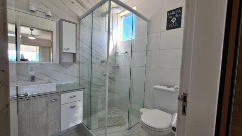 uma casa de banho com um chuveiro, um WC e um lavatório. em Pousada Ingleses Beach em Florianópolis