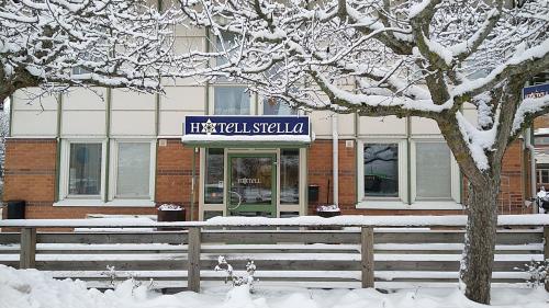 a building with a sign on it in the snow at Hotel Charlotte / Stella in Uppsala