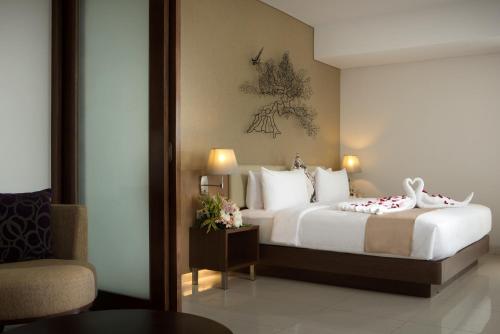 Habitación de hotel con cama y silla en Hotel Santika Premiere Kota Harapan Indah, en Bekasi