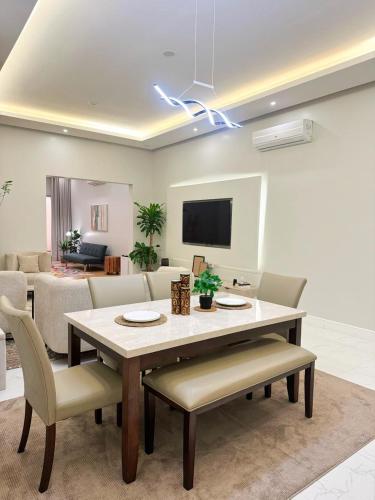 a dining table and chairs in a living room at شقق مودرن مقابلة البوليفارد in Riyadh