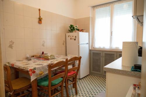 a kitchen with a table and a white refrigerator at Discover Sustainable Bliss: 2-BR Apartment in Rome in Rome