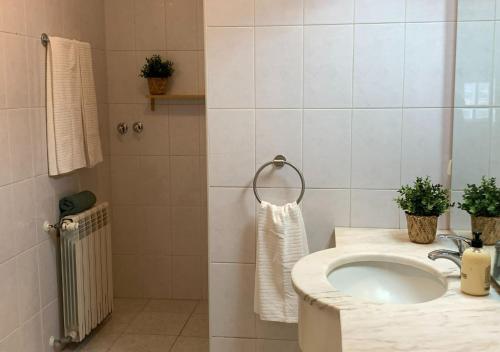 La salle de bains est pourvue d'un lavabo et d'une douche. dans l'établissement Casa d'Avó Maria - Alojamento rural familiar, à Marco de Canavezes