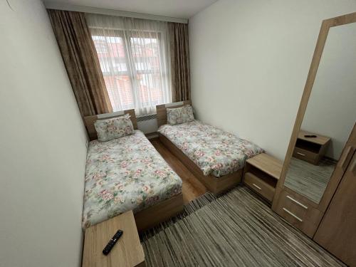 a small room with two beds and a mirror at Marina Apartment in Bansko