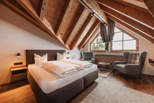 a bedroom with a large bed and two chairs at Ischgl Panorama in Kappl