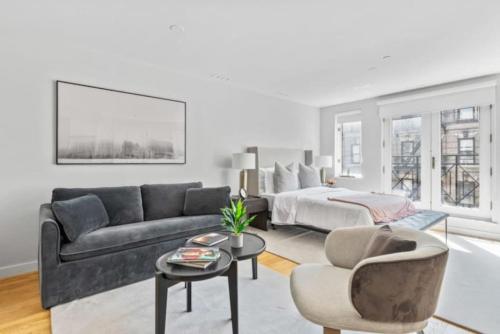 ein Wohnzimmer mit einem Sofa und einem Bett in der Unterkunft Luxe Studio with Charming Juliet Balcony in New York