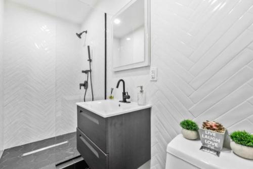 ein Badezimmer mit einem Waschbecken, einem Spiegel und einem WC in der Unterkunft Luxe Studio with Charming Juliet Balcony in New York