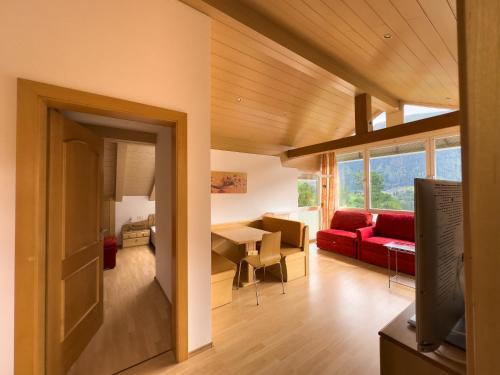 a living room with a red couch and a table at Posthof in Campo di Trens