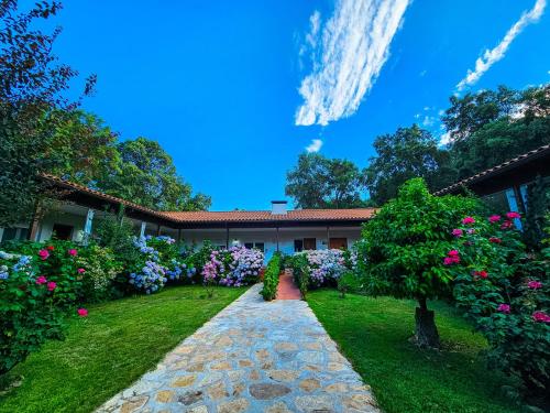 a house with a garden with flowers in the yard at Hotel Rural El Retiro de San Pedro by RetiroRural in Arenas de San Pedro
