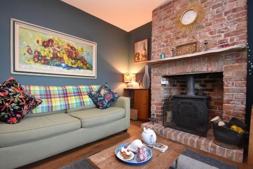 a living room with a couch and a fireplace at May's House in Rye Harbour