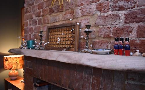 a brick wall with a table with wine bottles on it at May's House in Rye Harbour