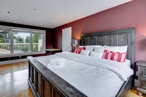 ein großes Schlafzimmer mit einem großen Bett mit roten Wänden in der Unterkunft Waterfront 4BR Cottage - Boat Deck and BBQ in Beaverton