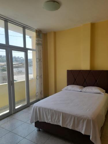 a bedroom with a bed and a large window at Departamento de Pablito Junto al Mar in Caleta Cruz