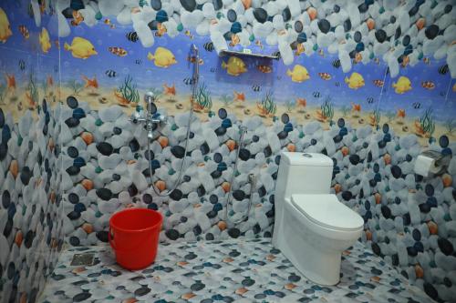 ein Bad mit einem WC und einer Felswand in der Unterkunft Marari Sophy Villa in Mararikulam