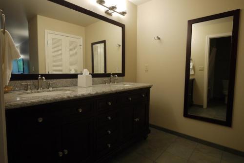 baño con lavabo y espejo grande en Redwood Hyperion Suites en Grants Pass