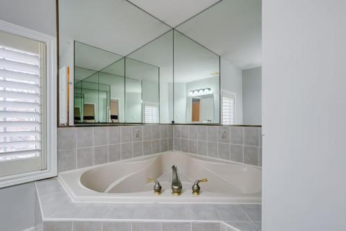 a bath tub with two faucets and a mirror at 4-BR Family Haven - Near Wonderland and Vaughan Mills in Vaughan