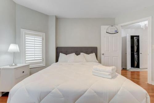 um quarto branco com uma grande cama branca com almofadas brancas em 4-BR Family Haven - Near Wonderland and Vaughan Mills em Vaughan