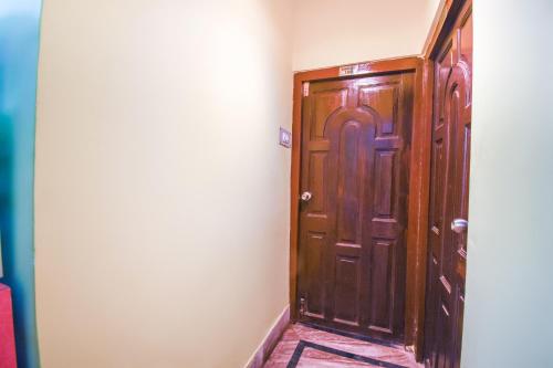 a wooden door in the corner of a room at OYO Petals Residency in Nager Bazaar