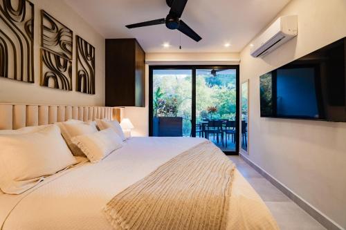 a bedroom with a large bed and a flat screen tv at 3018 - Ziba Condo 208 in Santa Cruz Huatulco