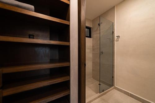 a walkin closet with wooden shelves and a shower at 3018 - Ziba Condo 208 in Santa Cruz Huatulco