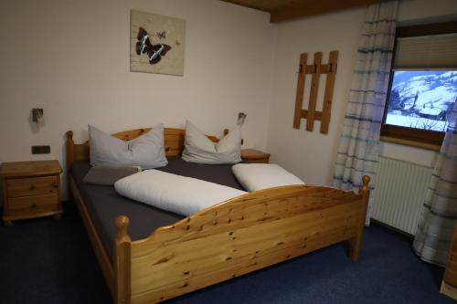 ノイシュティフト・イム・シュトゥーバイタールにあるFerienwohnung Kindl Manuelaのベッドルーム1室(白い枕の木製ベッド1台付)