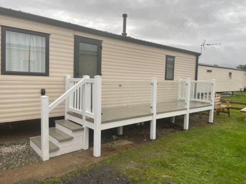 a mobile home with a porch and stairs on it at Mawson Retreat Dog Friendly Static Caravan in Millom