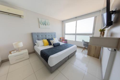 1 dormitorio con 1 cama y TV en Edificio Palmetto Beach Apto 1702, en Cartagena de Indias