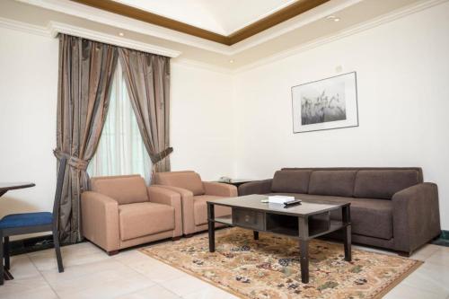 a living room with a couch and a coffee table at Delmon Hotel Suites in Jeddah