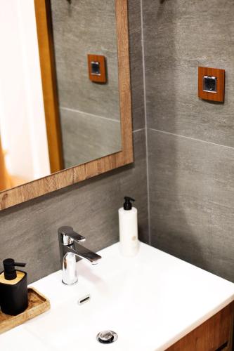a bathroom with a white sink and a mirror at UrbanKop Vidik Residence in Kopaonik