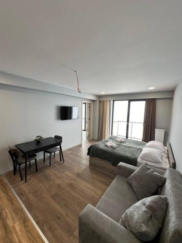 uma sala de estar com um sofá, uma cama e uma mesa em Gudauri Apartment em Gudauri