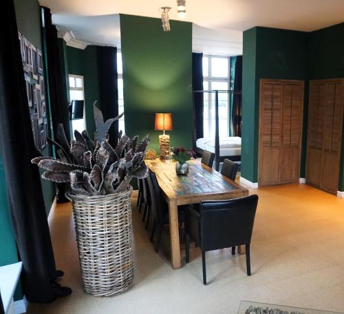 a dining room with a table and a vase with a plant at Hotel Bucheneck in Linz am Rhein