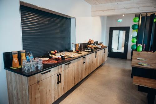 a large kitchen with a long counter with food on it at Kleiter´s BERGLERGHÜS in Blaichach