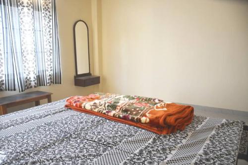 a bed with a comforter on it in a bedroom at Hilltop Abode in Guwahati