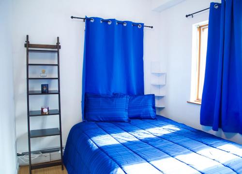 a bedroom with blue curtains and a bed with a ladder at BrightonBeach-Comfy Room-Close Ocean in Brooklyn