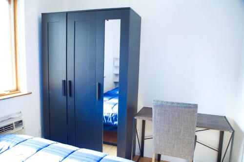 a bedroom with a blue cabinet and a table and a bed at BrightonBeach-Comfy Room-Close Ocean in Brooklyn