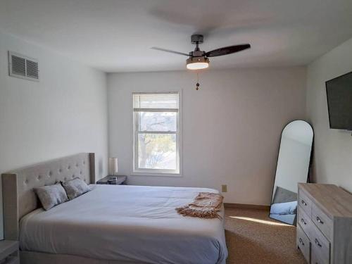 ein Schlafzimmer mit einem großen Bett und einem Fenster in der Unterkunft Comfort & Cozy 3/2 in Macomb, IL in Macomb