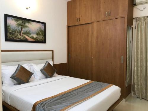 a bedroom with a bed with a wooden cabinet at Elevar Ayanna in Bangalore