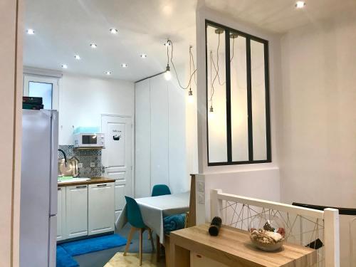 une cuisine avec une table et une salle à manger dans l'établissement Adorable souplex batignolles, à Paris