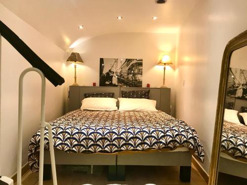 - une chambre avec un lit, deux lampes et un miroir dans l'établissement Adorable souplex batignolles, à Paris