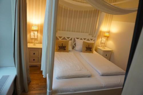 a bedroom with a white bed and two night stands at Hotel Bucheneck in Linz am Rhein