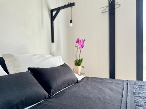 a bedroom with a bed and a vase with purple flowers at Civico36 in Ilbono