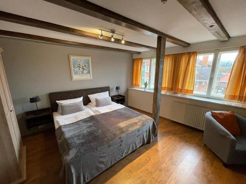 1 dormitorio con 1 cama, 1 silla y ventanas en Hotel Restaurant Iris en Bad Segeberg