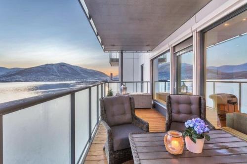 a balcony of a house with two chairs and a table at Beautiful home with seaview in Tromsø