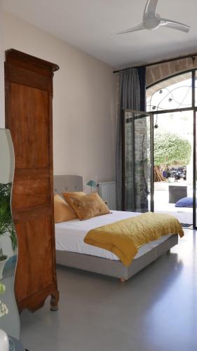 a bedroom with a bed and a wooden dresser at L'Escampe in Saturargues
