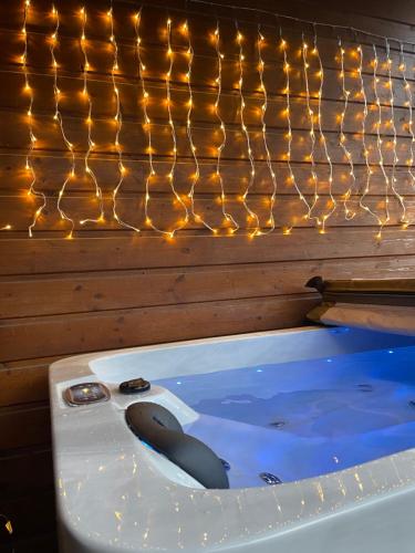 a jacuzzi tub with lights on a wall at Romantique chalet avec sauna et jacuzzi extérieur in Arthon