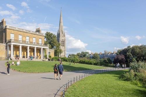 a group of people walking in front of a building at Deluxe room with lovely lake View in London